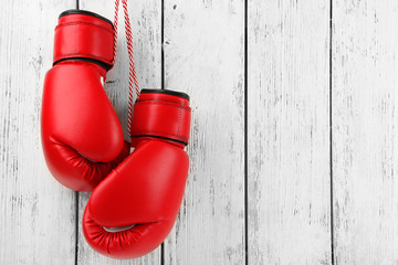 Pair of boxing gloves on color wooden background