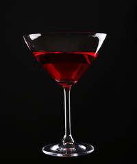 Colorful alcoholic beverage in glass on dark background