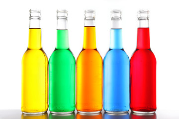Colorful alcoholic beverages in glass bottles isolated on white