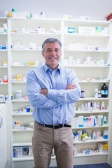 Naklejka na ściany i meble Portrait of a smiling pharmacist standing with arms crossed