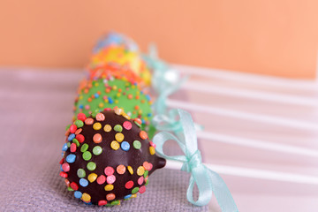 Sweet cake pops on table on beige background