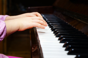 Obraz premium Little girl studing to play the piano
