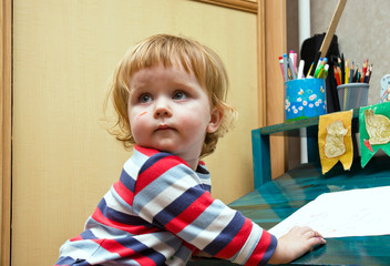 Cute little girl smearing by felt pen's colors