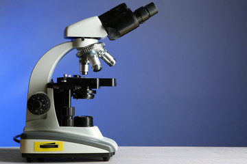 Microscope on table, on color background