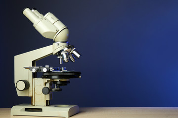 Microscope on table, on color background