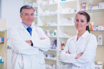 Pharmacist with his trainee standing with arms crossed