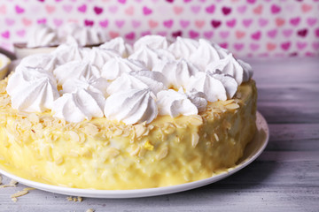 Tasty homemade meringue cake on wooden table, on pink
