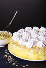 Tasty homemade meringue cake on wooden table, on grey