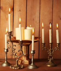 Retro candlesticks with candles on wooden background