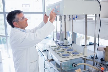 Scientist with safety glasses using the machine