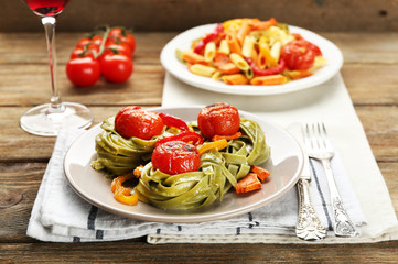 Two kinds of tasty pasta with pepper, carrot and tomatoes