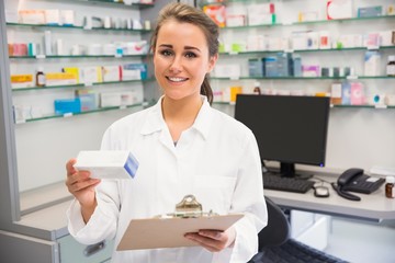 Junior pharmacist holding medicine box