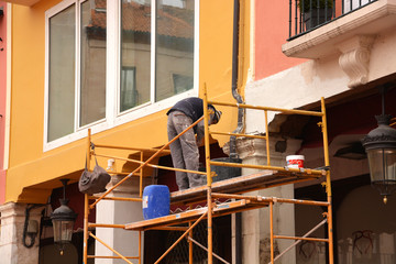 obrero trabajando encima de un andamio