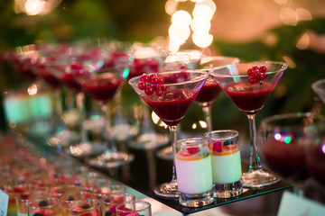 Line of different colored cocktails with smoke on a party