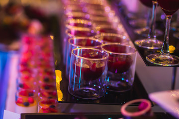 Line of different colored cocktails with smoke on a party