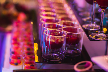 Line of different colored cocktails with smoke on a party