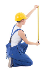 back view of sitting woman builder measuring something with meas