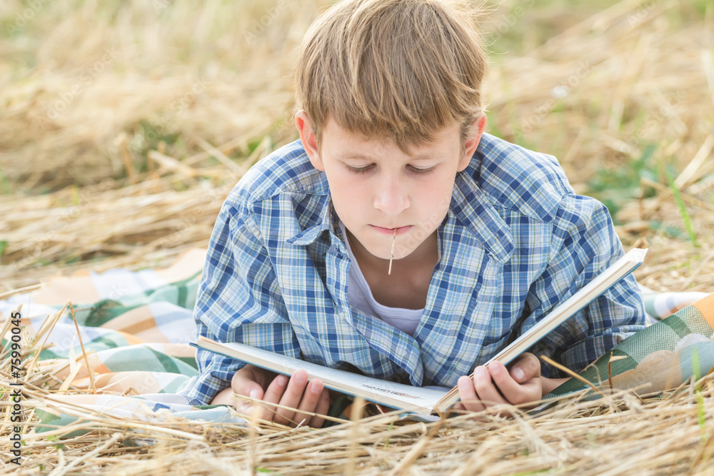 Wall mural teenage boy lying with book