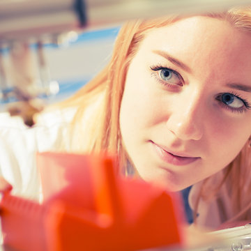 girl student makes the item on the 3D printer
