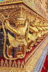 Obraz premium Golden Statue of Garuda catching Naga around Pavillion