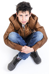 Obraz premium Portrait of a happy handsome guy sitting cross-legged