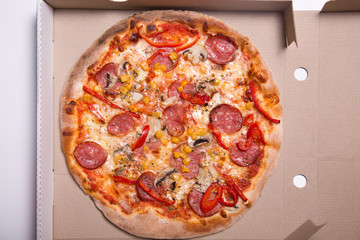 Tasty pizza with pepperoni and mushrooms in box