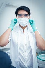 Fototapeta na wymiar Dentist wearing surgical mask and safety glasses