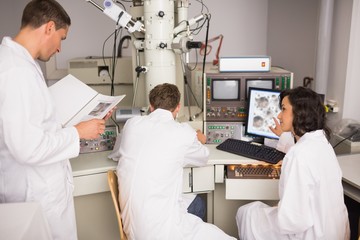 Obraz premium Biochemistry students using large microscope and computer