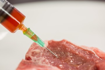 Food scientist injecting raw meat