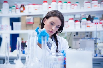 Concentrated female scientist using a pipette