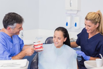 Dentist and nurse explaining to their patient how use toothbrush