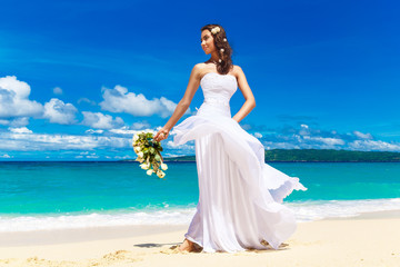 Fototapeta na wymiar beautiful brunette bride in white wedding dress with big long wh