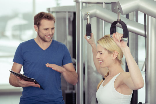 trainer im fitness-studio erklärt eine übung