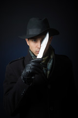 Man with a knife, studio shot, dark background