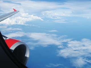 Naklejka na ściany i meble blue sky in clouds through airplane porthole