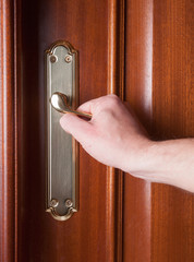 Hand gripping the handle of a door