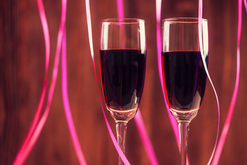 Two wineglasses with red wine over abstract background