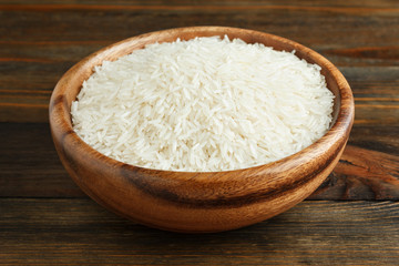 Fototapeta na wymiar Basmati rice in a wooden bowl on wood closeup