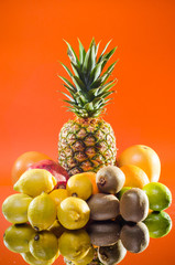 Still life pineapple and various fruits on orange background