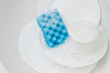 white dishes with  blue sponge