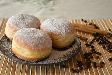 Donuts with powdered sugar on the brown plate