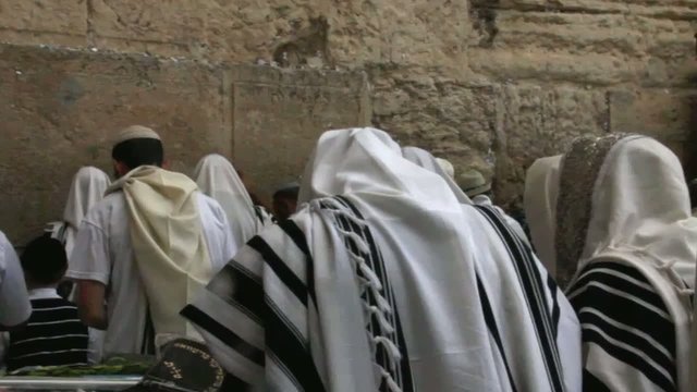 religious Jews in traditional white praying near Western Wall