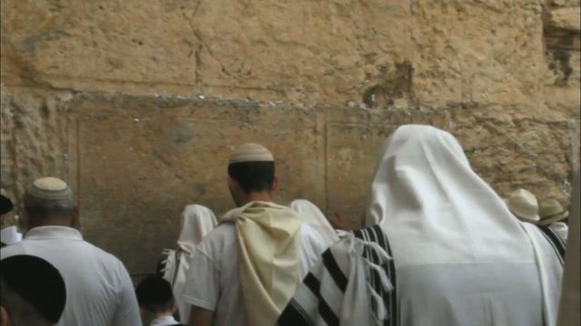religious Jews in traditional white praying near Western Wall