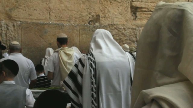 religious Jews in traditional white praying near Western Wall