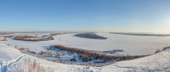 Winter panoramic landscape with frozen river from the high bank