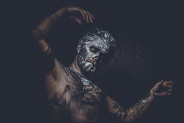 naked man covered with paint and mud skin