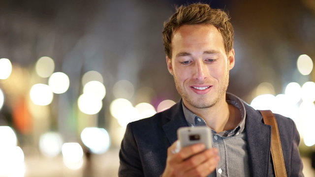 Man sms texting using app on smart phone at night
