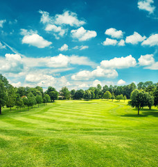 Golffeld und blauer bewölkter Himmel. Schöne Landschaft mit grünem g