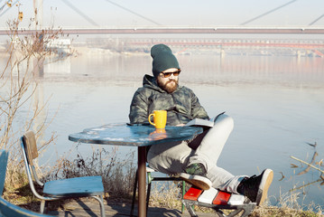 Man reading a book on the river