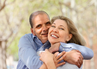 Happy senior lovers hugging each other and laughing